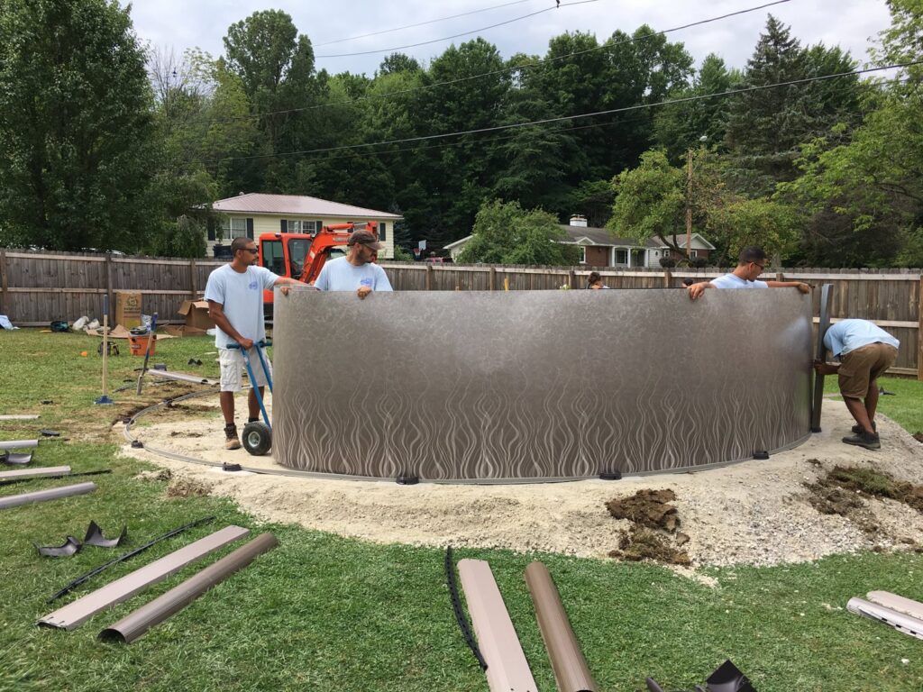 Workers installing an above-ground pool, demonstrating construction services by My Pool Guys of Erie, PA.