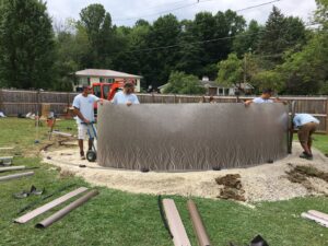 Workers installing an above-ground pool, demonstrating construction services by My Pool Guys of Erie, PA.