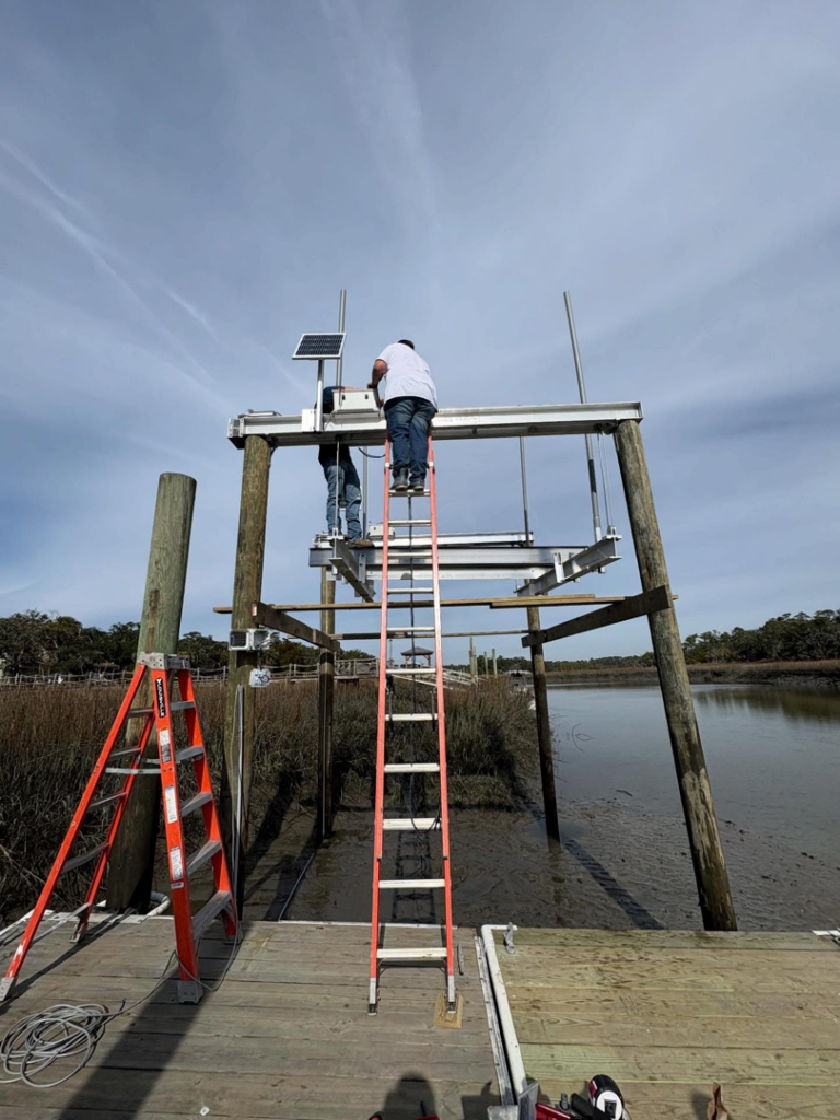 Workers installing a boat lift and dock structure over water for Coastal Dock and Resurfacing in Beaufort, SC.