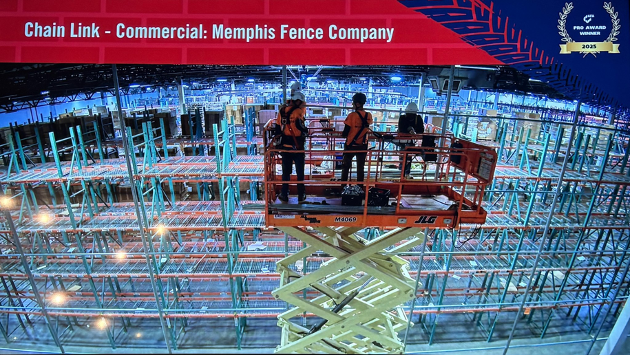 Workers on a scissor lift installing commercial chain link fencing inside a large warehouse for Memphis Fence Company, LLC in Memphis, TN.