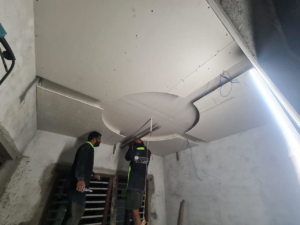 Two workers expertly installing decorative ceiling drywall with intricate designs for TechPro Constructions in Houston, TX.