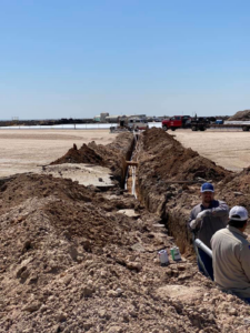 Workers installing electrical conduits in a trench for Harvey's Electric in Perryton, TX