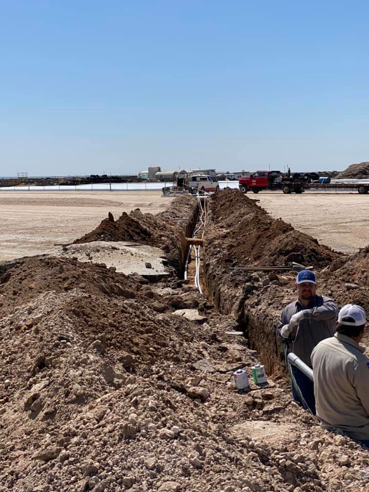Workers installing electrical conduits in a trench for Harvey's Electric in Perryton, TX