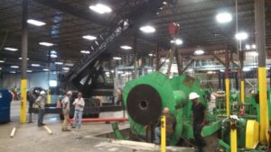Workers from Tidewater Crane & Contracting installing a large green industrial machine in Virginia Beach, VA
