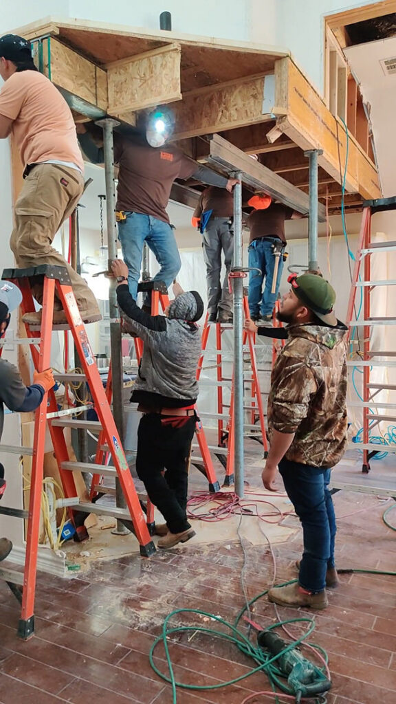 Workers installing a new load-bearing beam with temporary supports for Load Bearing Wall Pros in Plano, TX.