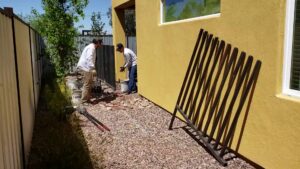 Workers installing a metal fence panel for Affordable Fence & Gates in Tucson, AZ.