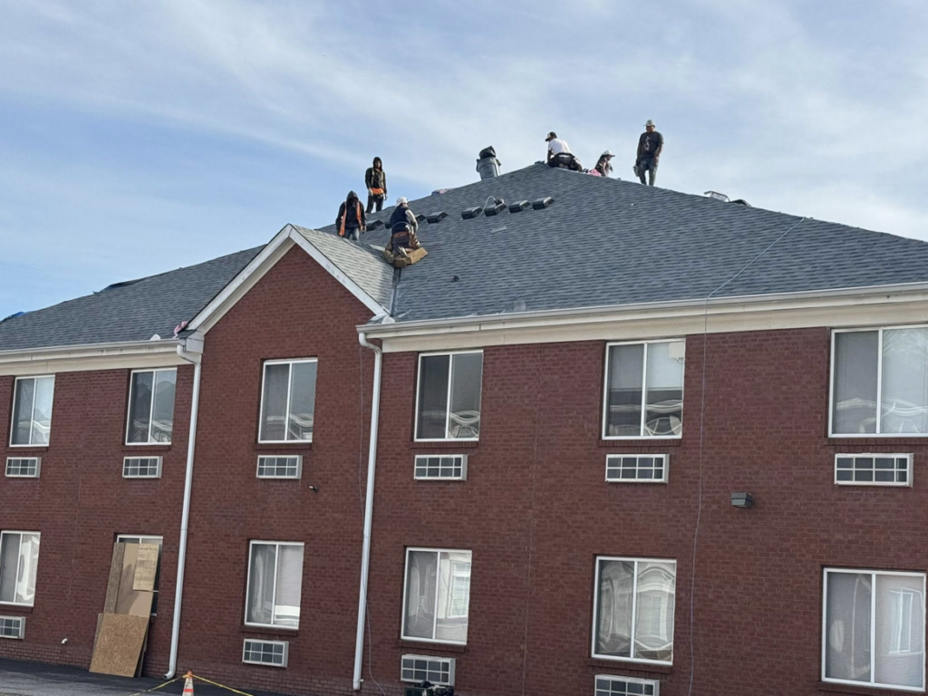 Workers installing a new shingle roof on a commercial building for Elegant Home Exteriors in Flourance, KY.