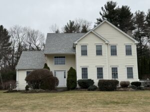 Workers installing new roof shingles on a house, a remodeling service by Casanova Remodeling in Plymouth, CT.