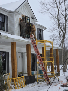 Two skilled workers installing a new window on a house, a service provided by 1st Choice Windows in Canton, OH.