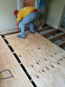 Workers installing plywood subfloor in a residential renovation by JMQ Contractor INC in Philadelphia, PA