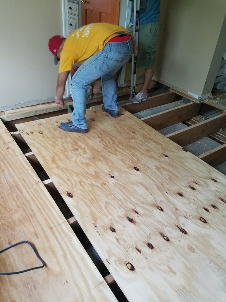 Workers installing plywood subfloor in a residential renovation by JMQ Contractor INC in Philadelphia, PA