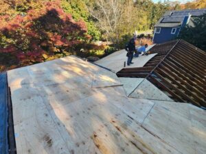 Workers installing new plywood sheathing on a roof for Universal Builders LLC in New Haven, CT.