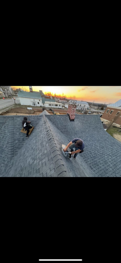 Two workers actively installing shingles on a residential roof, demonstrating the services of Conway's Roofing in Richmond, KY.