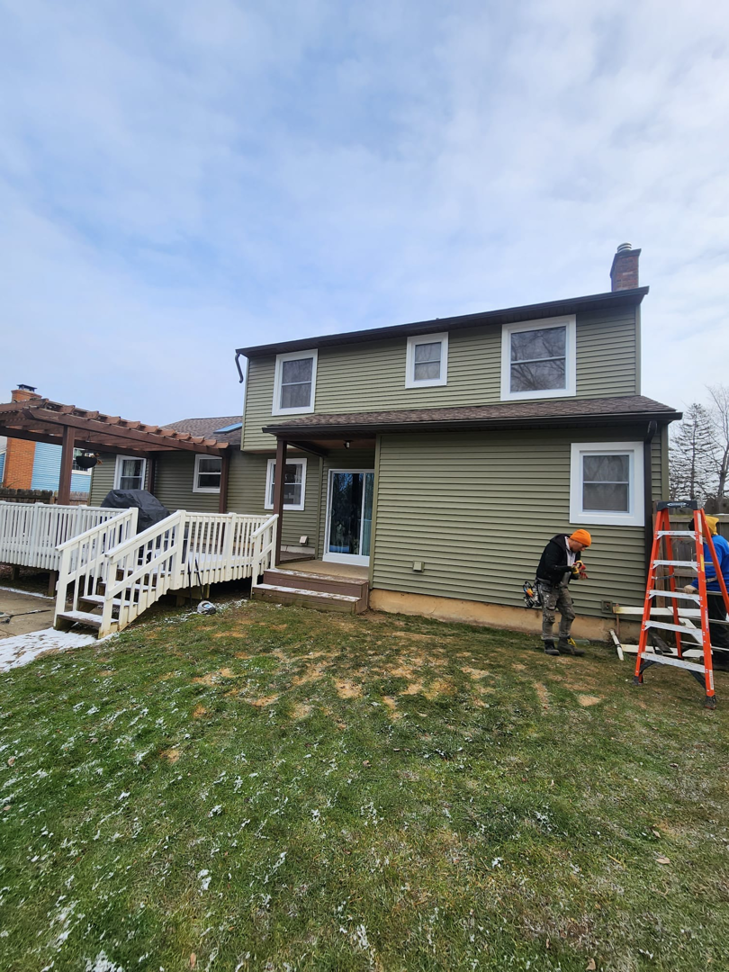Workers installing siding and windows during a house renovation by The Best Larry Roofing corp in Mechanicsburg, PA