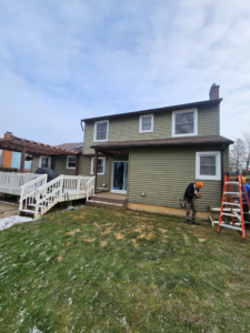 Workers installing siding and windows during a house renovation by The Best Larry Roofing corp in Mechanicsburg, PA