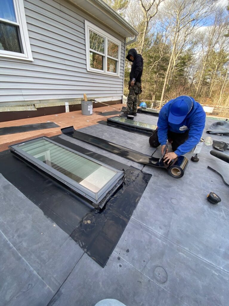 Workers installing new skylights and performing roof repairs on a residential property for Eagle Exteriors in Cumberland, RI.