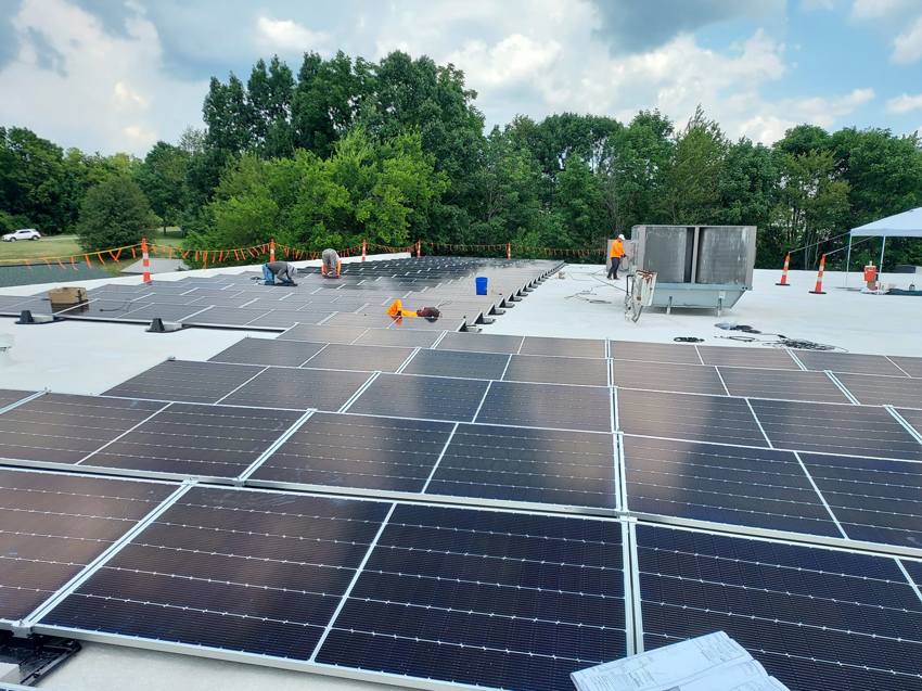 Workers installing new solar panels on a commercial rooftop for Solar by Ecos in Louisville, KY.