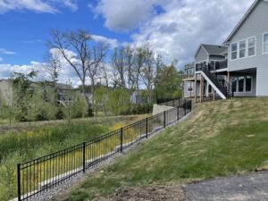 Two workers installing new wooden fence posts for a property by Security Fence & Construction Inc in Minneapolis, MN.