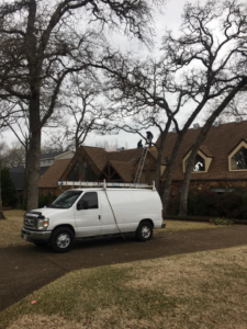 Workers on a residential house roof with a work van during a project by TYCO Roofing & Construction LLC in Allen, TX.