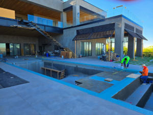 Workers on a large pool construction site, performing handyman tasks for Premier Paradise, Inc. in Gilbert, AZ.