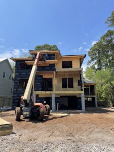 Workers on a lift during house construction by Sanddollar Building & Remodeling Inc in Hilton Head Island, SC.