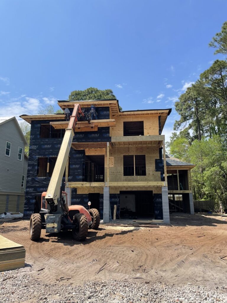 Workers on a lift during house construction by Sanddollar Building & Remodeling Inc in Hilton Head Island, SC.