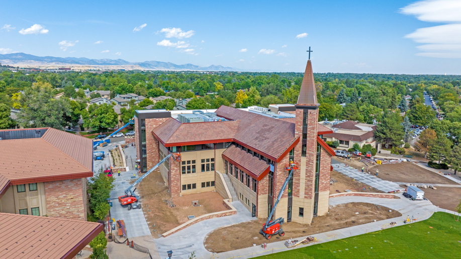 Workers on boom lifts performing exterior building maintenance for Bell SPI - Shamrock Painting in Denver, CO.