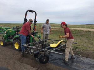 Workers using a tractor with a specialized attachment to plant tree rows by Tree Rows 4 U in Bismarck, ND.