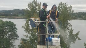 Two workers on a boom lift performing pressure washing services for Infinity Maintenance Services, Inc. in Brattleboro, VT.
