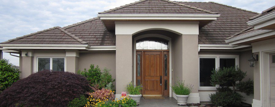Workers removing old roof shingles from a house, a remodeling service by Casanova Remodeling in Plymouth, CT.