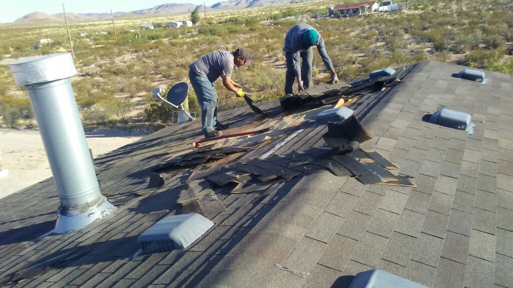 Workers removing old shingles from a residential roof for Villalobos Remodeling & Construction in El Paso, TX