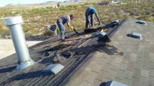 Workers removing old shingles from a residential roof for Villalobos Remodeling & Construction in El Paso, TX