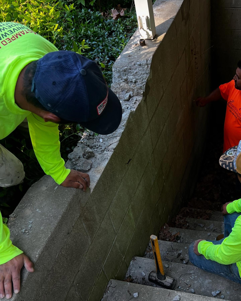 Workers repairing a concrete block wall and stairs, demonstrating handyman services by Lafayette Concrete & Remodel, LLC in Lafayette, IN