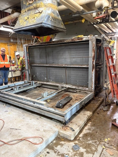 Two workers in safety gear servicing a large industrial HVAC unit for StructSure Projects in Kansas City, MO.