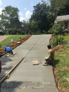 Workers smoothing a newly poured concrete driveway at a job site for Allen's Concrete Finishing in Rock Hill, SC.