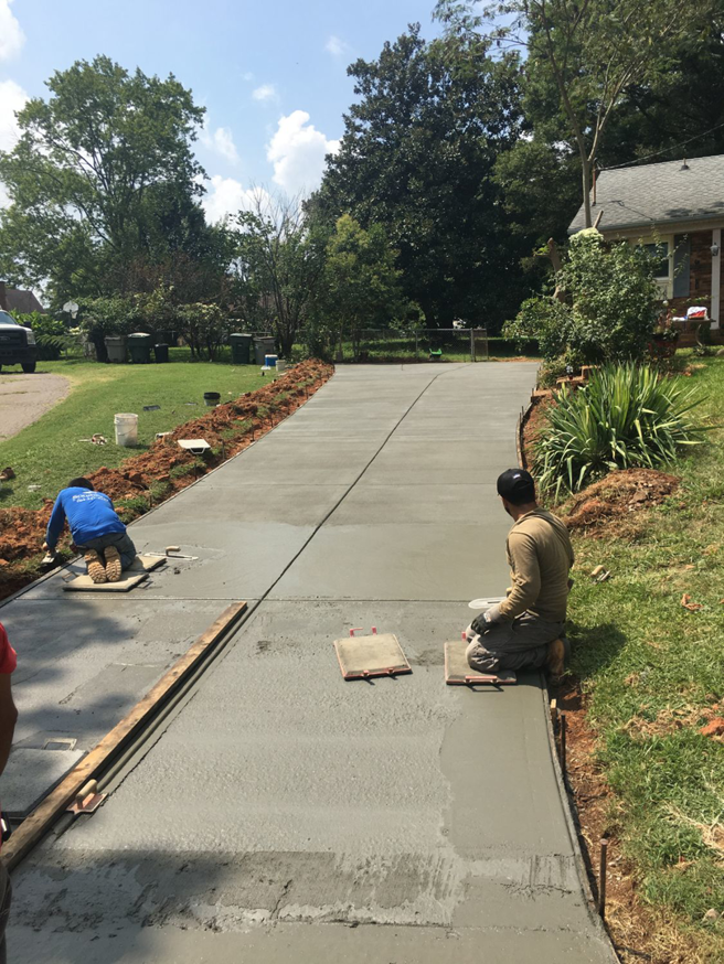 Workers smoothing a newly poured concrete driveway at a job site for Allen's Concrete Finishing in Rock Hill, SC.