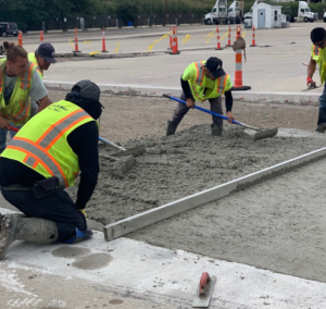 Workers spreading and leveling concrete for a large slab project by Cervantes Concrete Llc in Caledonia, WI.