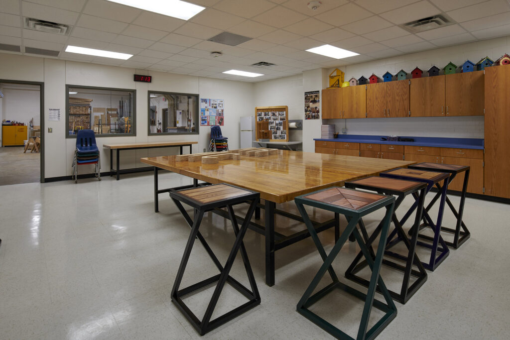 Interior of a workshop or classroom with large work tables and stools, completed by Reeder General Contractors, Inc. in Fort Worth, TX