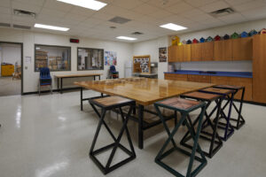 Interior of a workshop or classroom with large work tables and stools, completed by Reeder General Contractors, Inc. in Fort Worth, TX