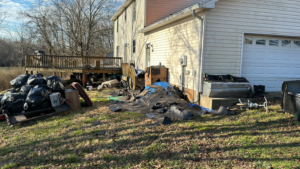 A messy yard with construction debris and trash bags ready for removal by Music City Exteriors in Nashville, TN