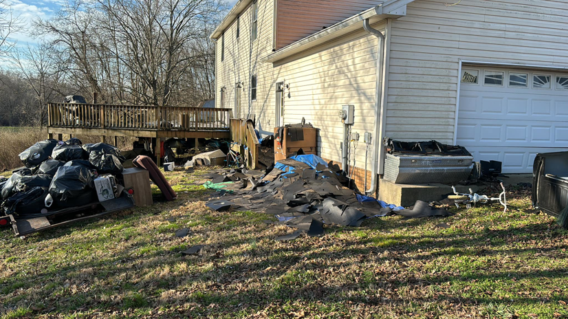 A messy yard with construction debris and trash bags ready for removal by Music City Exteriors in Nashville, TN