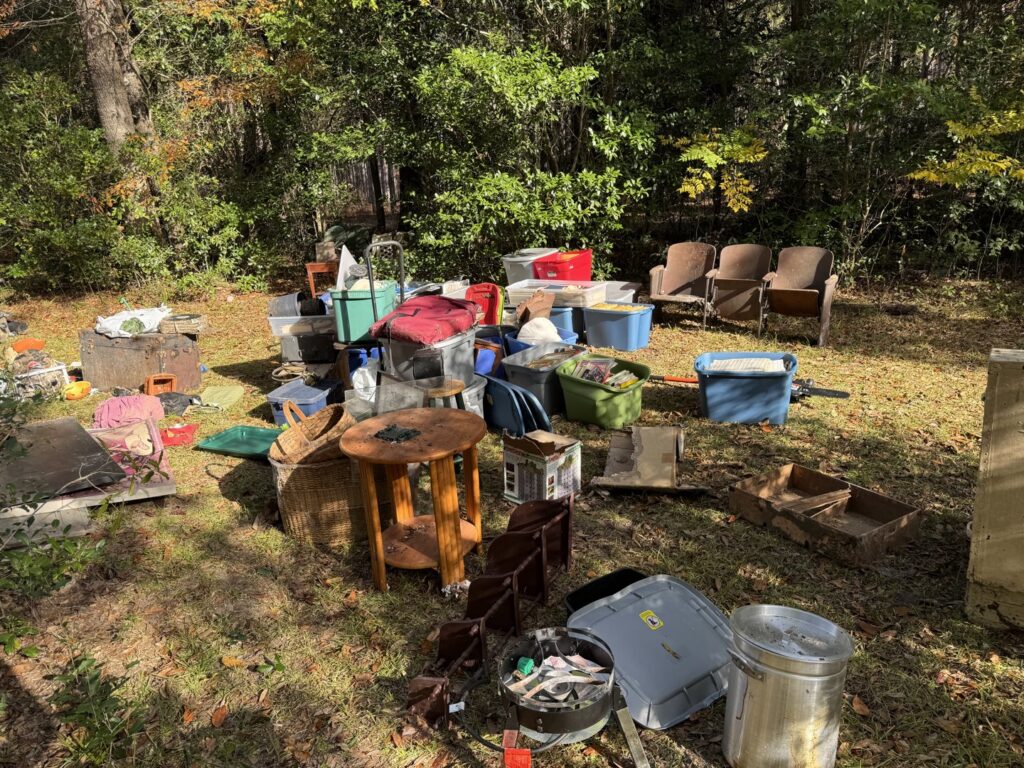 A large collection of household junk, furniture, and various items scattered in a yard, ready for removal by L.P.Z Trash & Junk Removal in Tallahassee, FL.