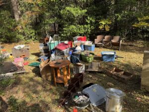 A large collection of household junk, furniture, and various items scattered in a yard, ready for removal by L.P.Z Trash & Junk Removal in Tallahassee, FL.
