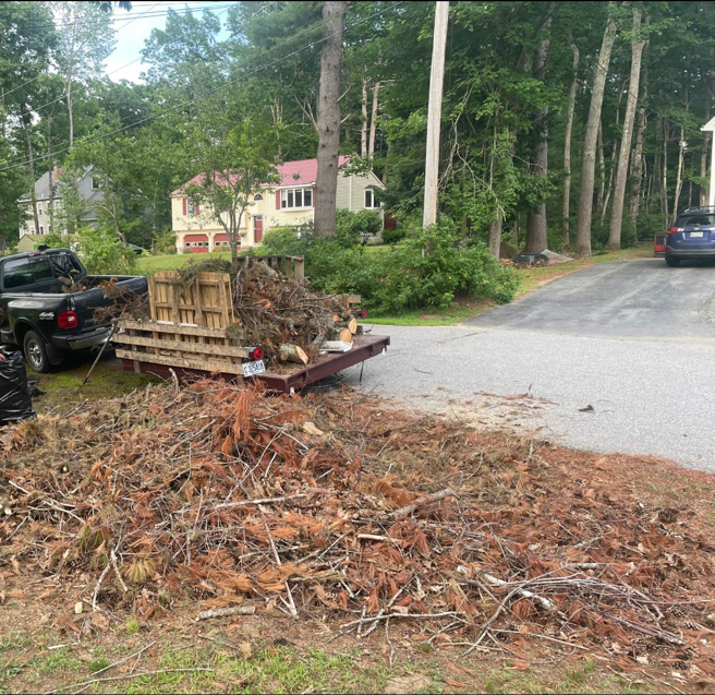 A pickup truck and trailer loaded with yard waste and tree debris for hauling by Mr. Property Service in Sanford, ME.