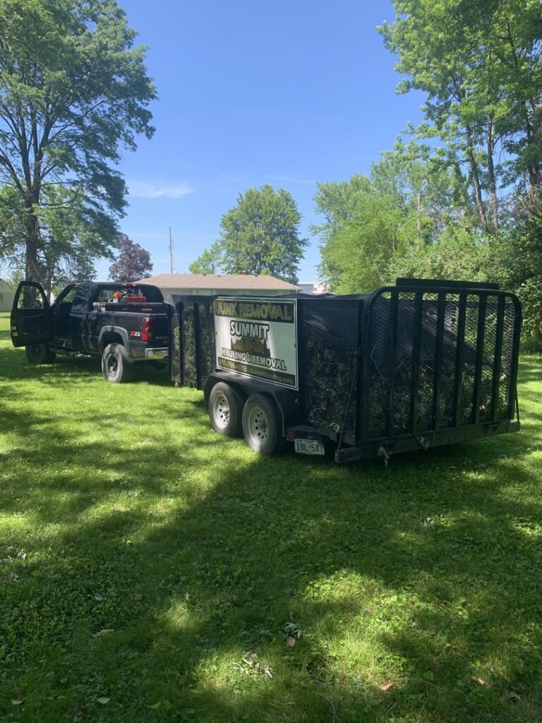 A Summit Hauling & Removal truck and trailer filled with tree branches and yard waste in Lee's Summit, MO.
