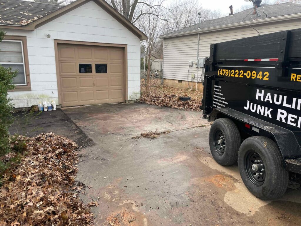 A Strong Lion Junk Removal trailer parked in a driveway, ready for yard waste and leaf removal services in Fayetteville, AR.