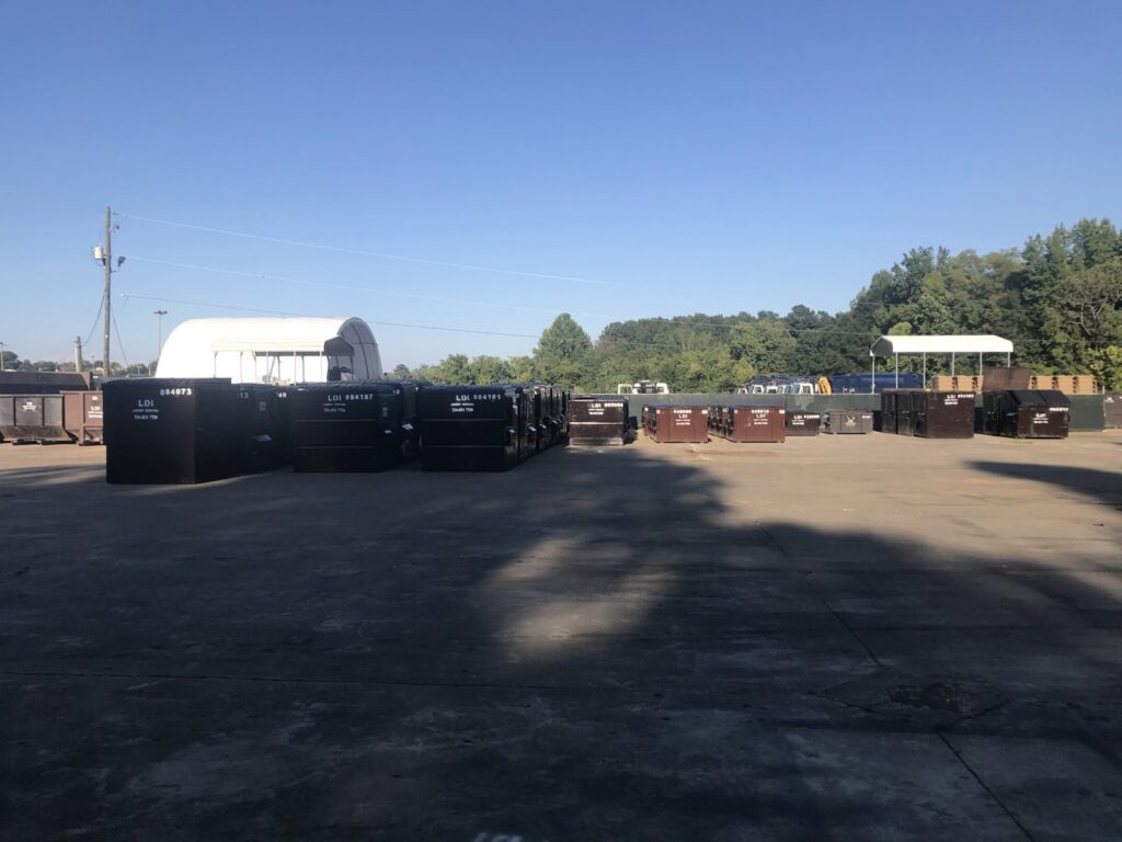 A large yard filled with multiple brown dumpsters and roll-off containers for Liberty Disposal, Inc. in Tucson, AZ.