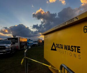 A yellow Delta Waste Solutions dumpster at a food truck event, providing waste solutions and junk removal in Hattiesburg, MS.
