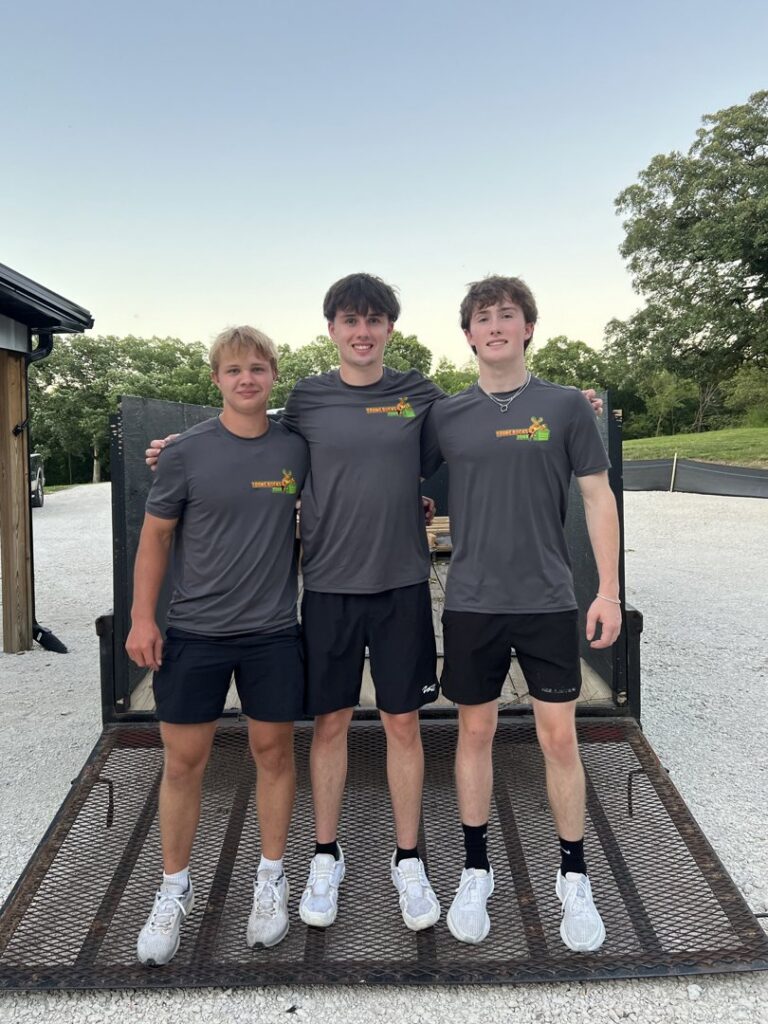 The Young Bucks Junk crew standing on the ramp of their empty junk removal trailer in Shawnee, KS.