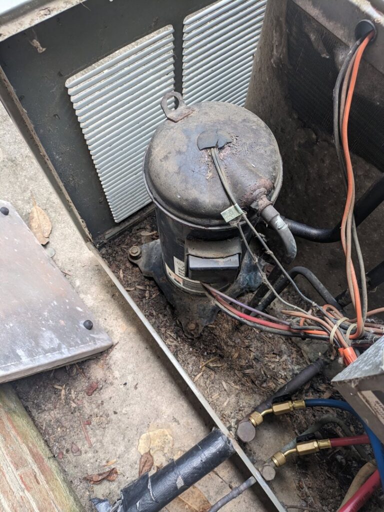 A close-up view of an AC compressor during an inspection by Honesty Services in Rock Hill, SC.